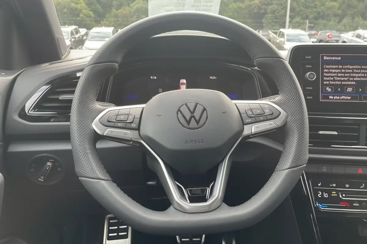 Vue rapprochée du volant multifonction du Volkswagen T-Roc noir grenadilla, version R-Line Black 2025, avec tableau de bord digital.