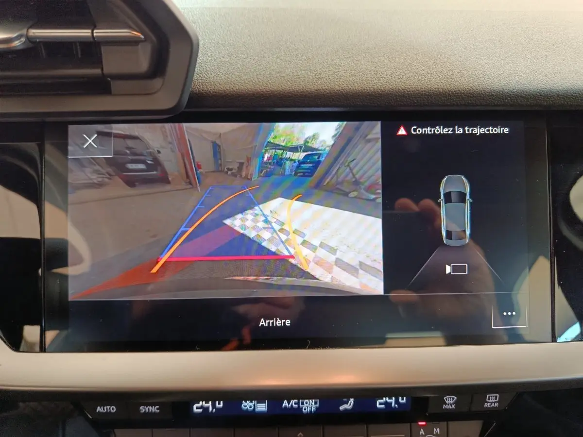 Écran tactile intérieur montrant la caméra de recul avec guidage dynamique sur Audi A3 noire, vue arrière.