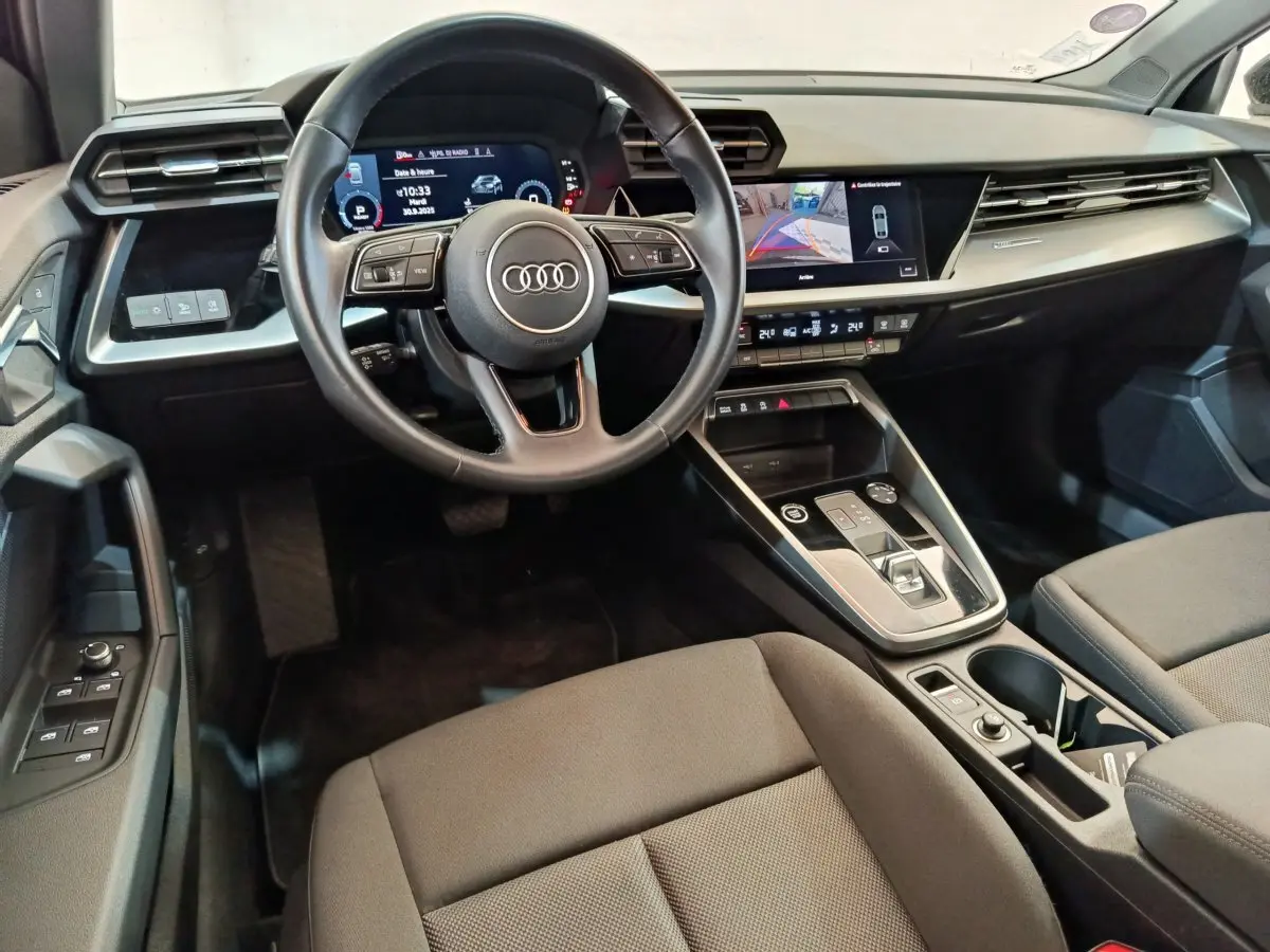 Intérieur noir de l'Audi A3 2022 vu côté conducteur, avec tableau de bord digital et écran tactile central.
