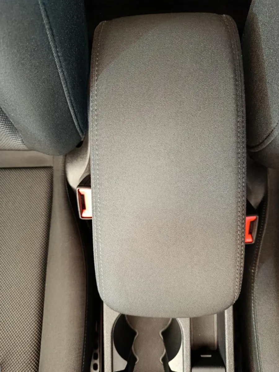 Vue plongeante sur l'accoudoir central noir et les sièges tissu foncé de l'Audi A3 30 TFSI MHEV Business Line 2022.