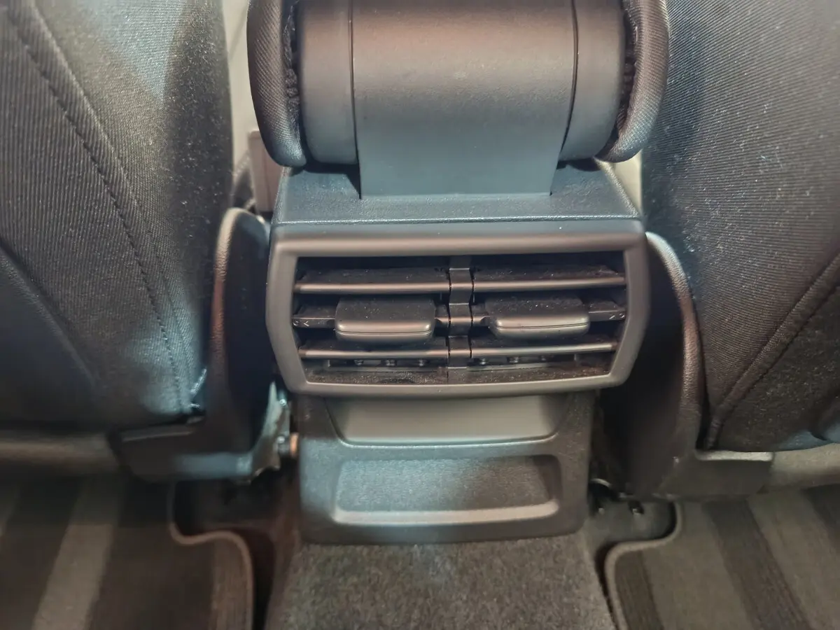 Vue rapprochée des aérateurs arrière noirs entre les sièges avant d'une Audi A3 30 TFSI MHEV Business Line 2022.