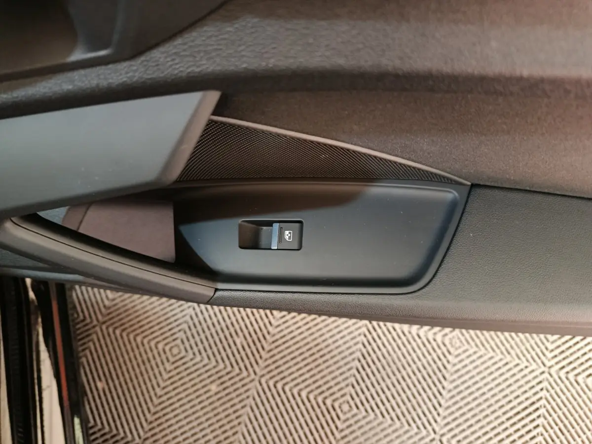 Détail de la commande de lève-vitre côté conducteur sur la porte intérieure noire d'une Audi A3 2022.
