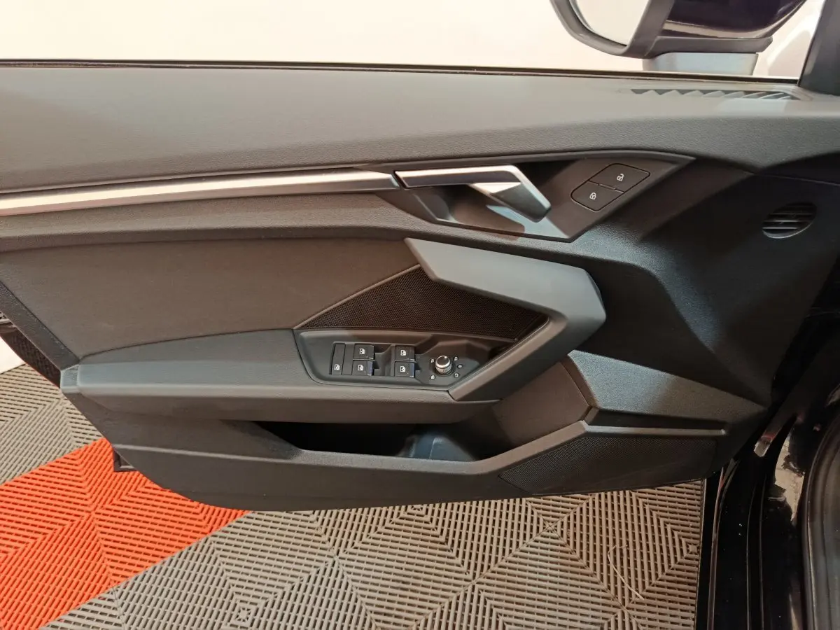 Panneau de porte côté conducteur noir de l'Audi A3 30 TFSI MHEV 2022 avec commandes électriques et verrouillage.