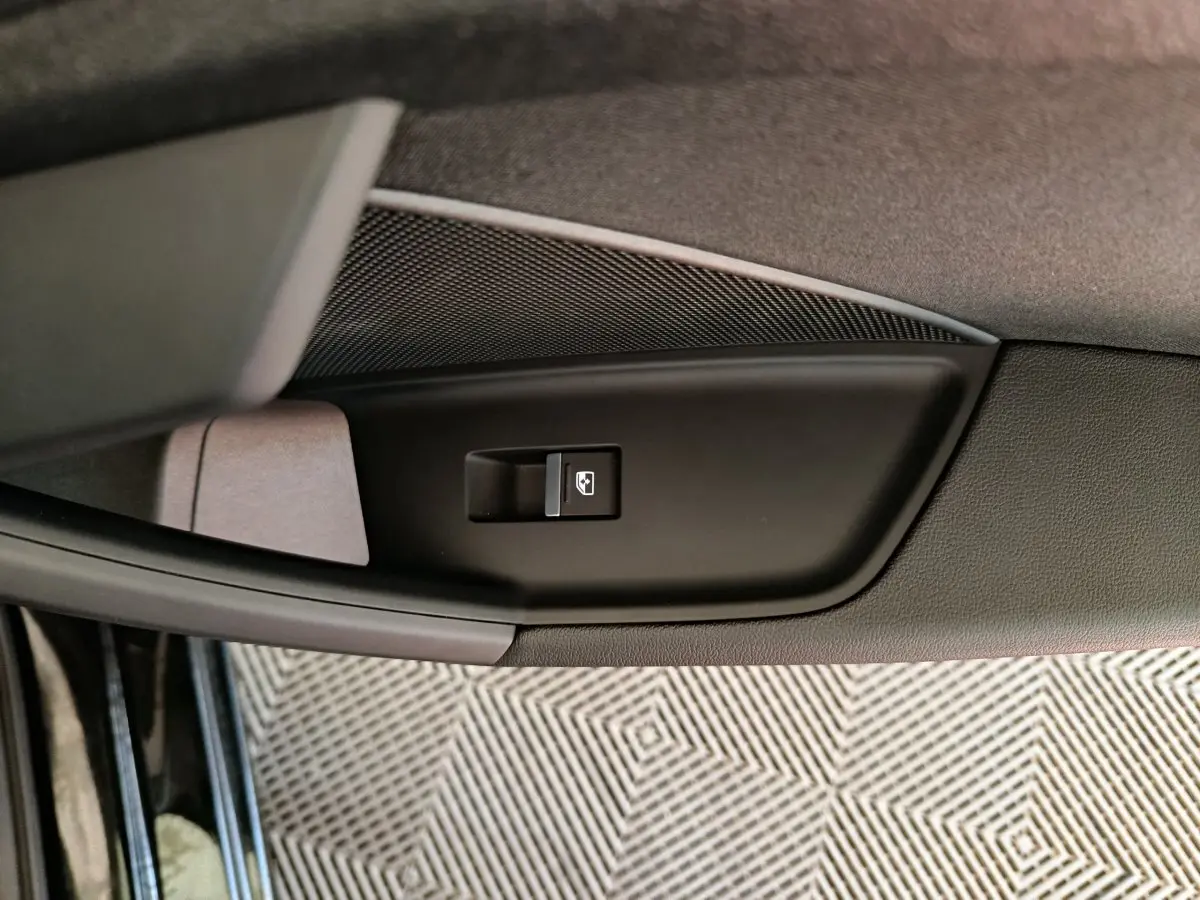 Bouton de commande de lève-vitre côté gauche sur la porte intérieure noire d'une Audi A3 30 TFSI MHEV 2022.