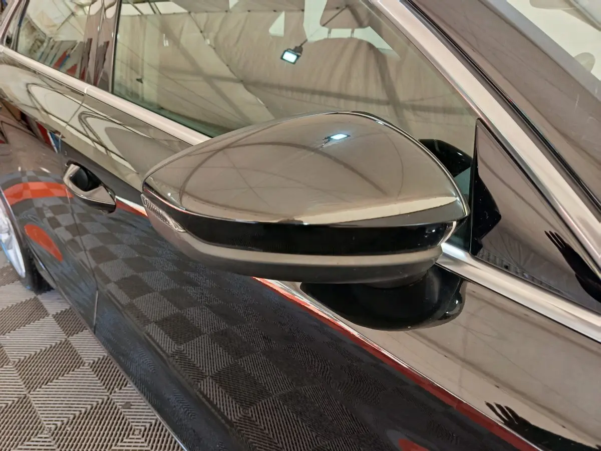 Rétroviseur côté gauche noir brillant de l'Audi A3 30 TFSI MHEV S Tronic 2022 avec carrosserie noire réfléchissante.