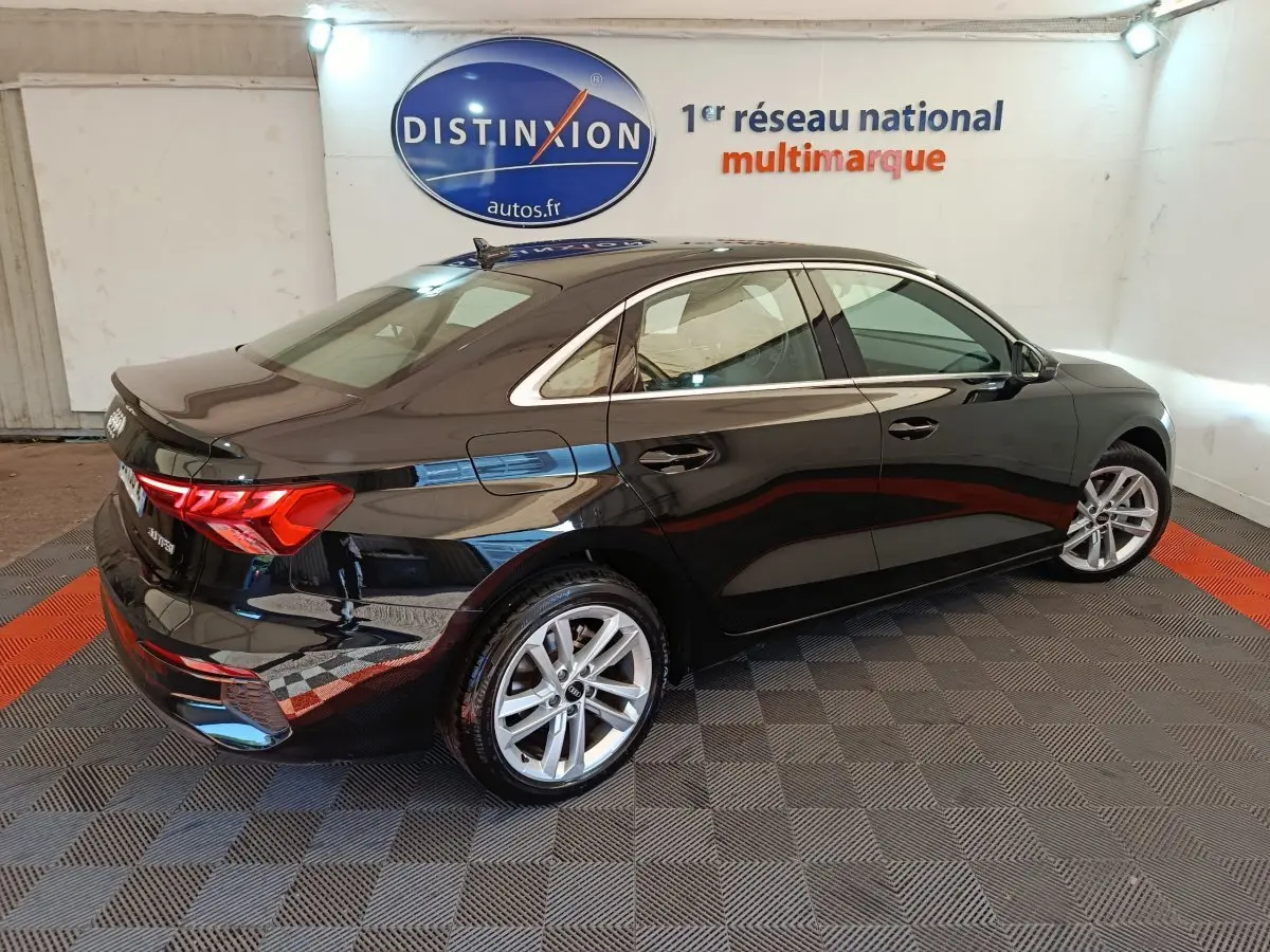 Audi A3 30 TFSI MHEV noir vue 3/4 arrière droit, avec jantes alliage et feux arrière LED distinctifs.