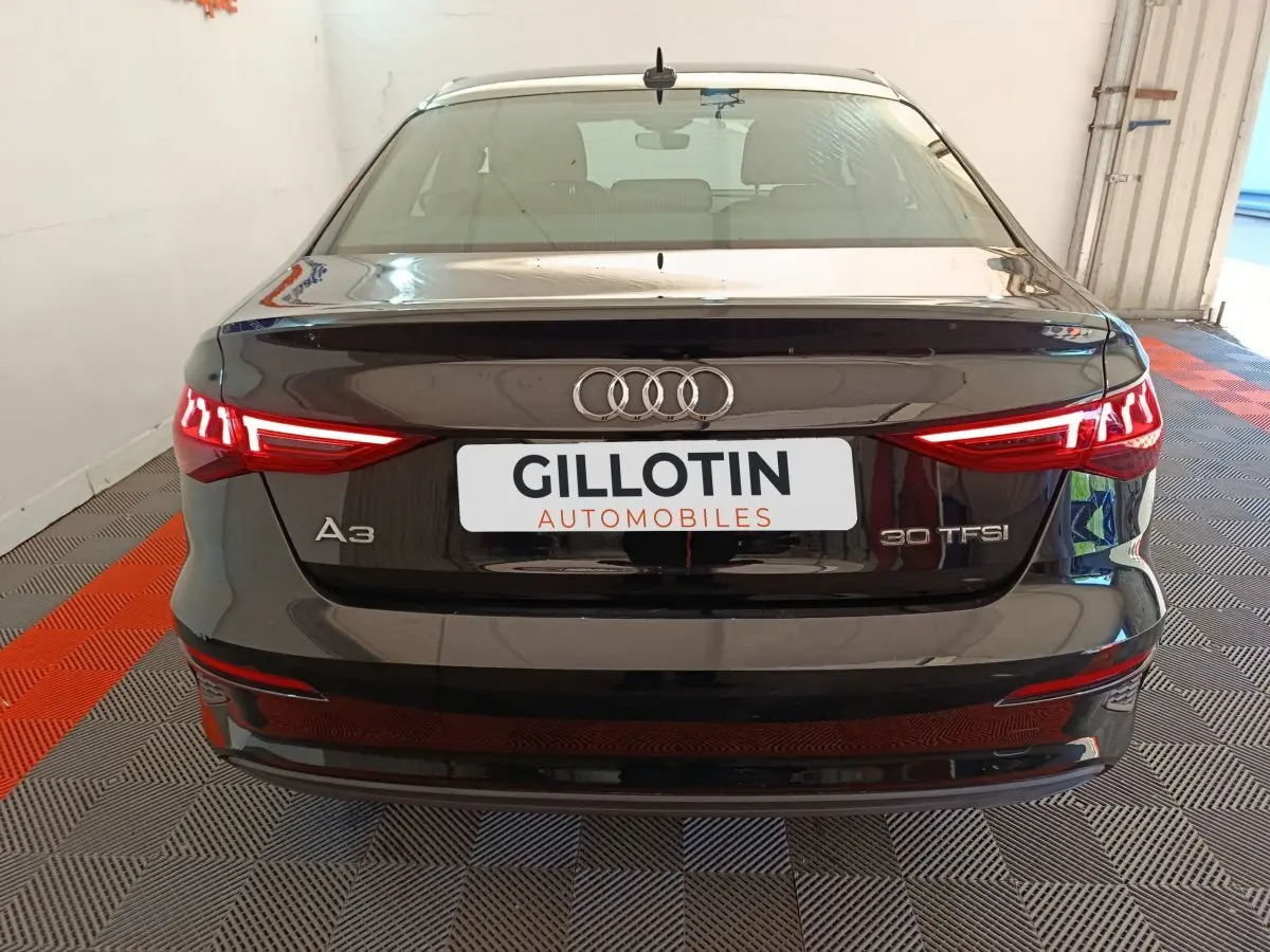 Vue arrière d'une Audi A3 noire 30 TFSI avec feux LED distinctifs et logo Audi bien visible.