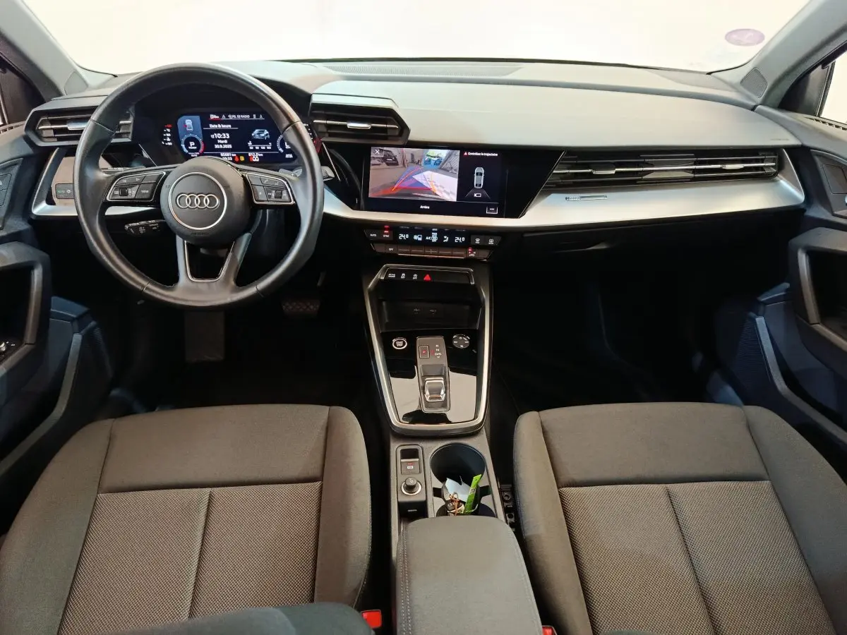 Intérieur Audi A3 30 TFSI MHEV 2022 vu de face, tableau de bord noir avec écran tactile et volant cuir multifonctions.