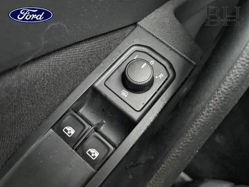 Détail des commandes de réglage des rétroviseurs et des vitres électriques côté conducteur, intérieur noir.