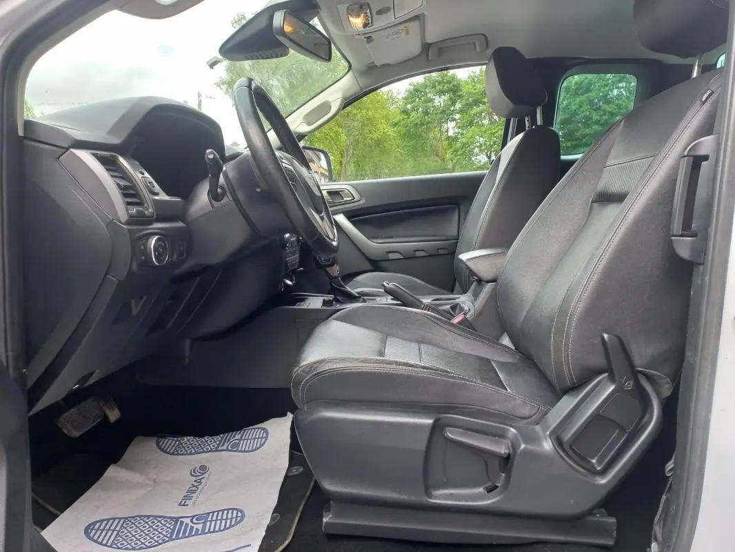 Vue intérieure côté conducteur du Ford Ranger Super Cabine Limited 2022, sièges noirs et tableau de bord visible.