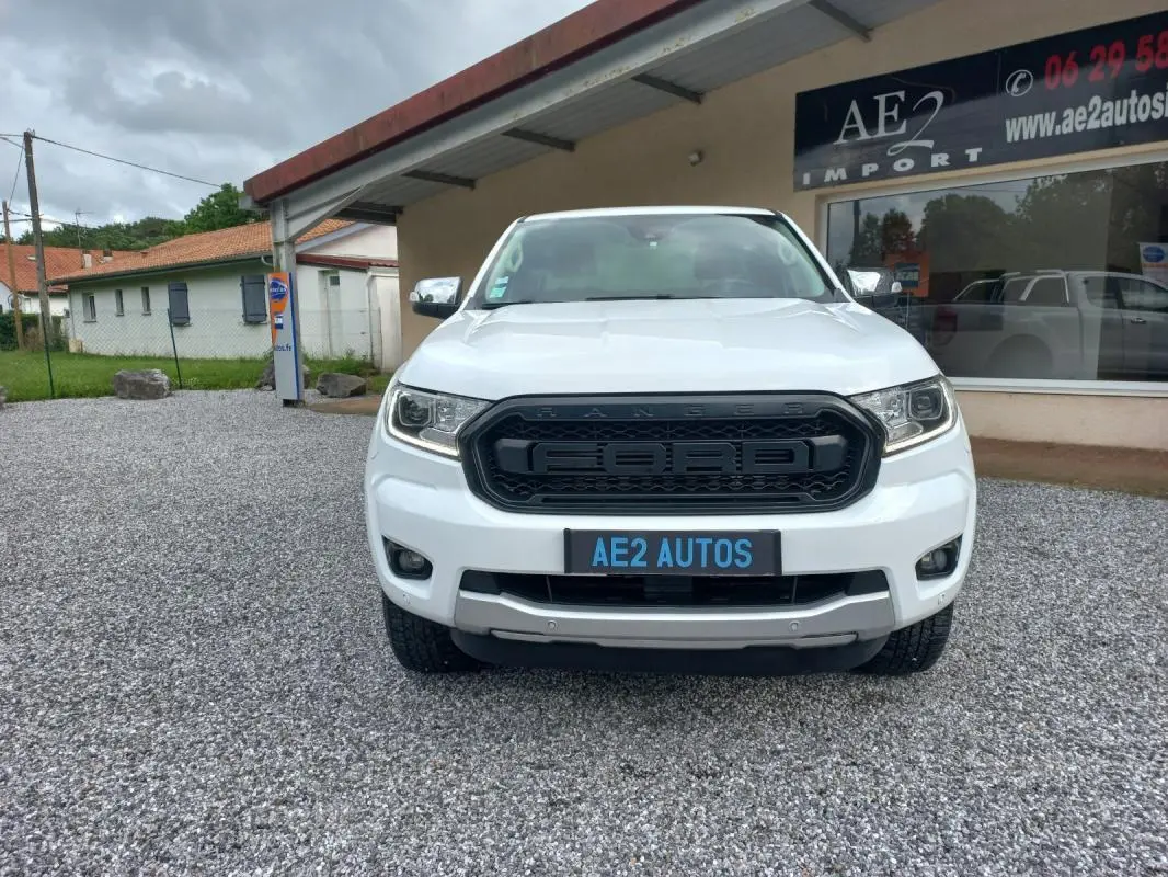 Vue de face d'un Ford Ranger blanc 2022 avec calandre noire marquée Ford et plaque AE2 AUTOS visible.