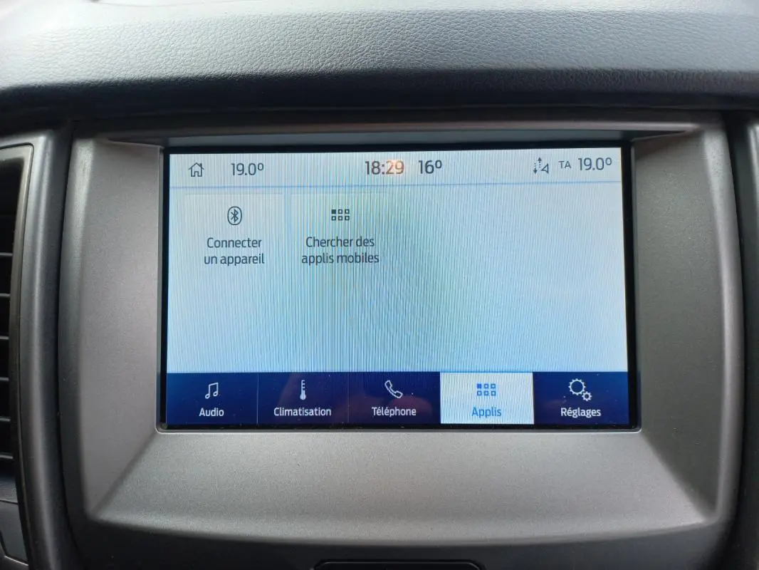 Écran tactile central du Ford Ranger blanc 2022, affichant les options audio, climatisation, téléphone et applications.