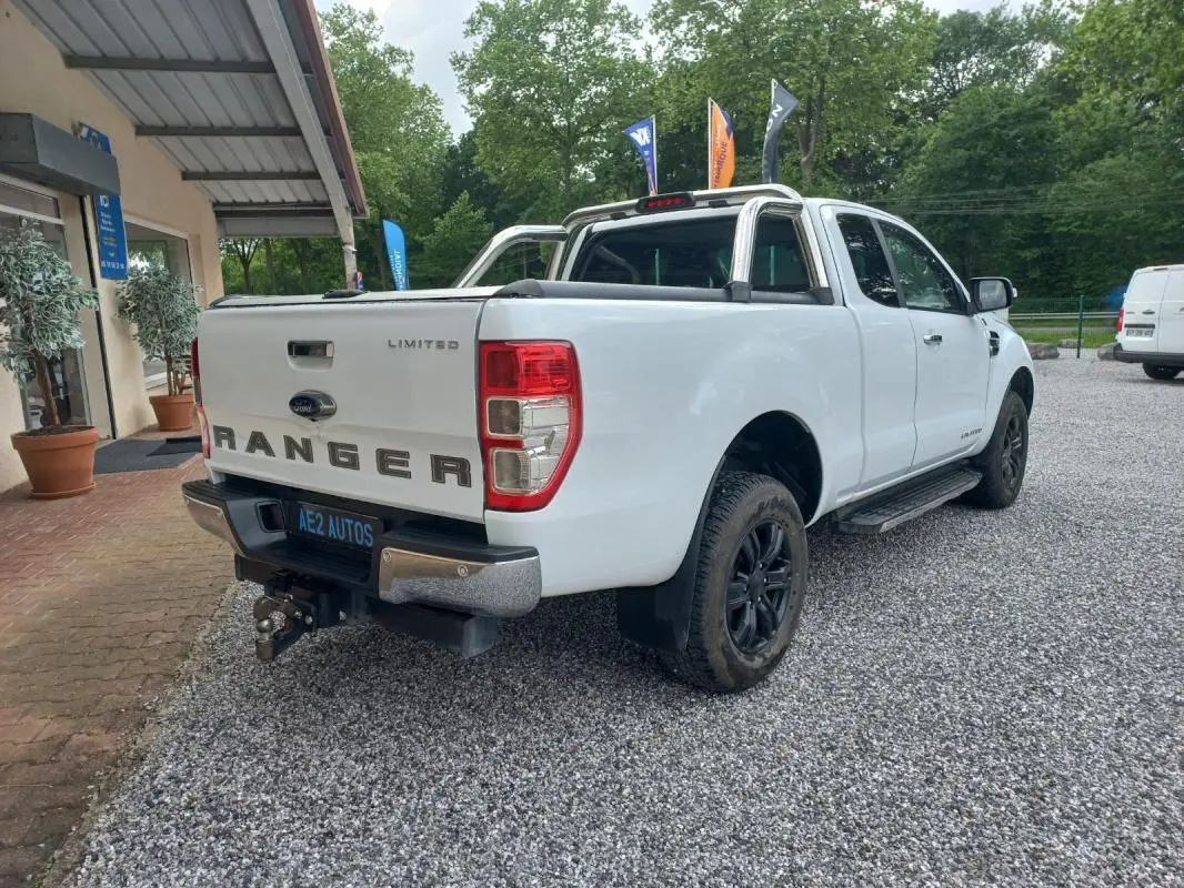 Ford Ranger Super Cabine Limited blanc vu 3/4 arrière droit avec barres de protection et attelage.