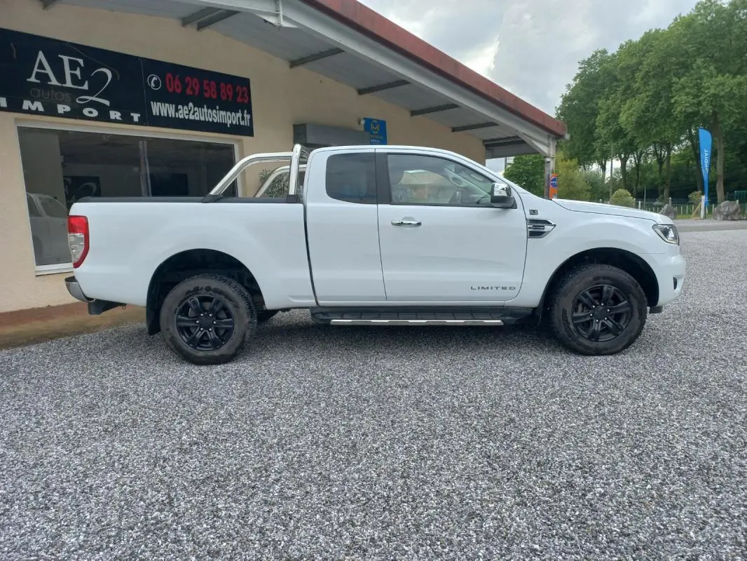 Ford Ranger Super Cabine Limited blanc vu de profil côté gauche, avec barres de protection et jantes noires.