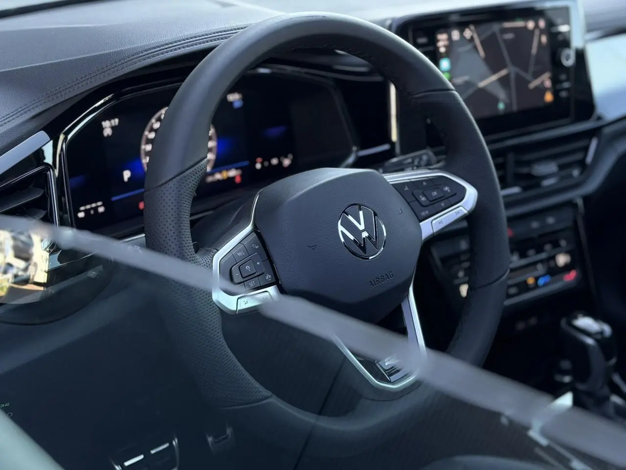 Volant sport multifonction noir avec logo Volkswagen, tableau de bord digital et écran tactile du Volkswagen T-Roc 2025.