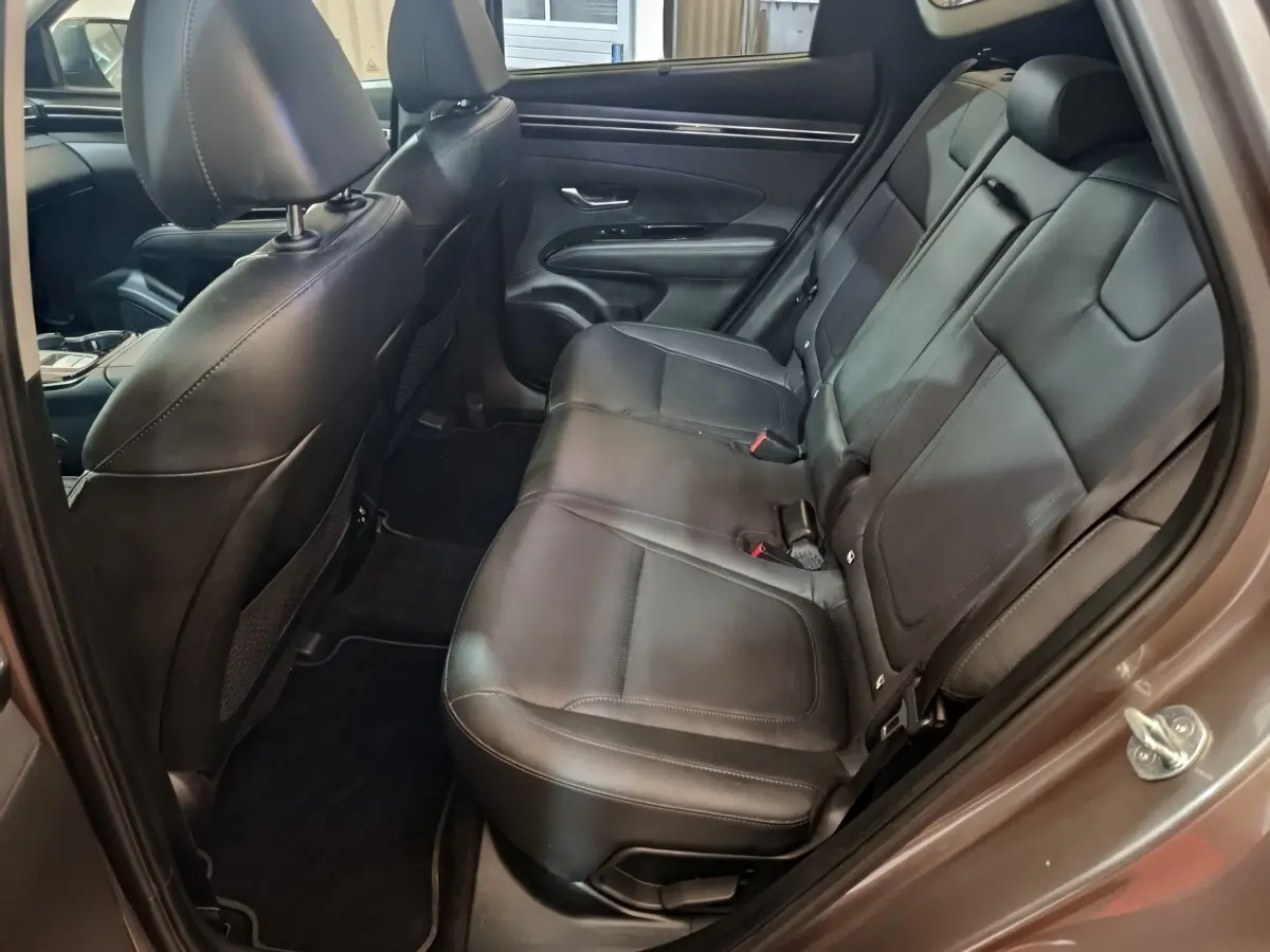 Vue intérieure côté droit sur les sièges arrière en cuir noir du Hyundai Tucson marron 2022 hybride rechargeable.