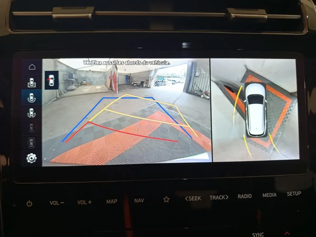 Affichage écran 360° du Hyundai Tucson marron 2022 en marche arrière avec lignes de guidage colorées visibles.