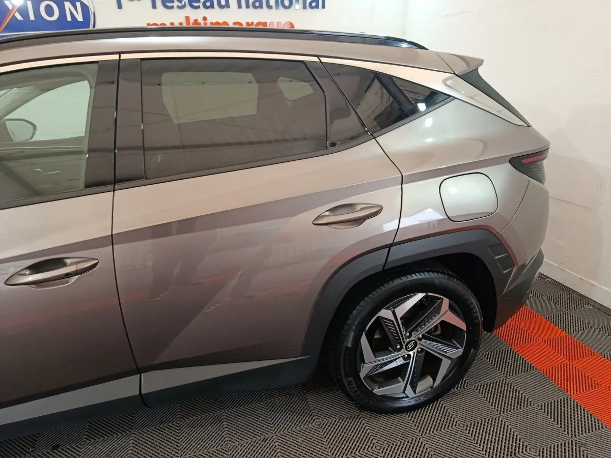 Vue latérale droite du Hyundai Tucson marron 2022, mettant en valeur la porte arrière et la roue arrière au design moderne.