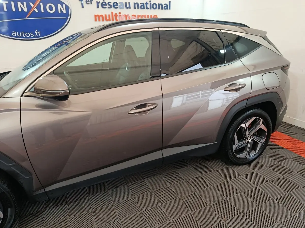 Vue latérale côté gauche du Hyundai Tucson marron 2022, soulignant ses lignes anguleuses et ses jantes modernes.