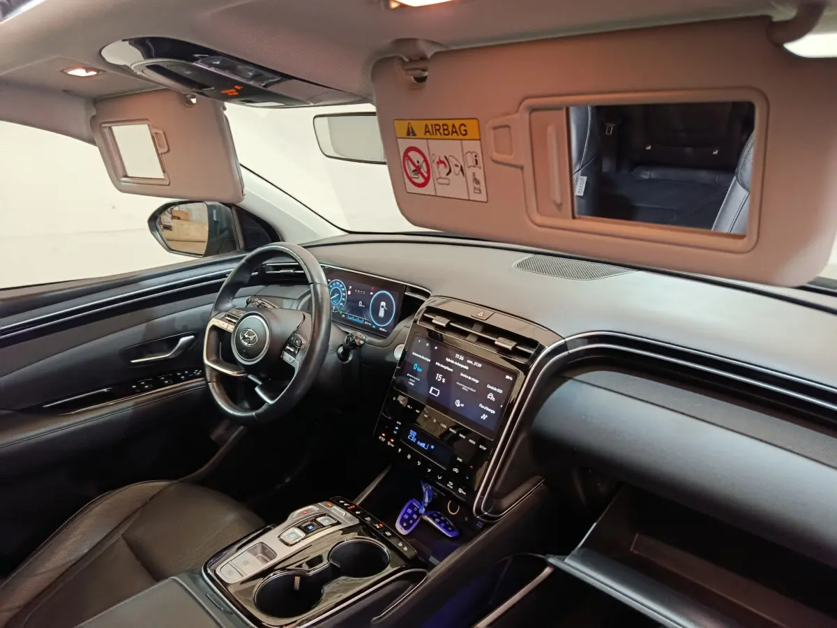 Intérieur du Hyundai Tucson 2022 vu côté conducteur, tableau de bord numérique et écran tactile central noir.