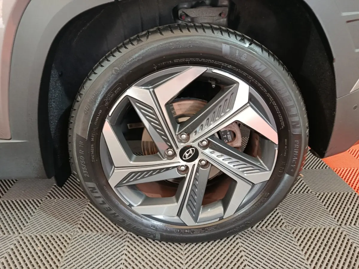 Gros plan sur la roue avant droite du Hyundai Tucson marron 2022, mettant en valeur la jante alliage et le pneu Michelin.