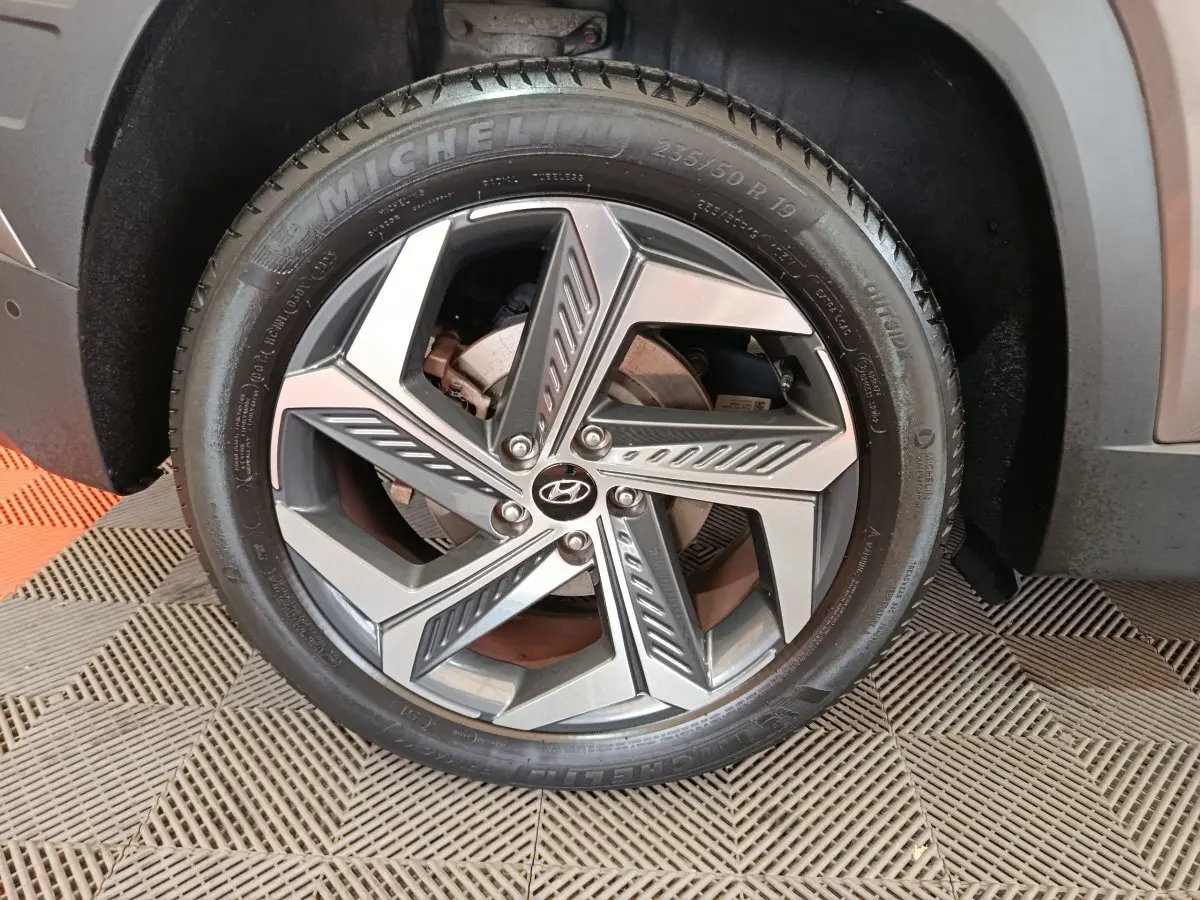 Gros plan sur la jante alliage moderne avec logo Hyundai du côté avant droit du Tucson marron 2022.