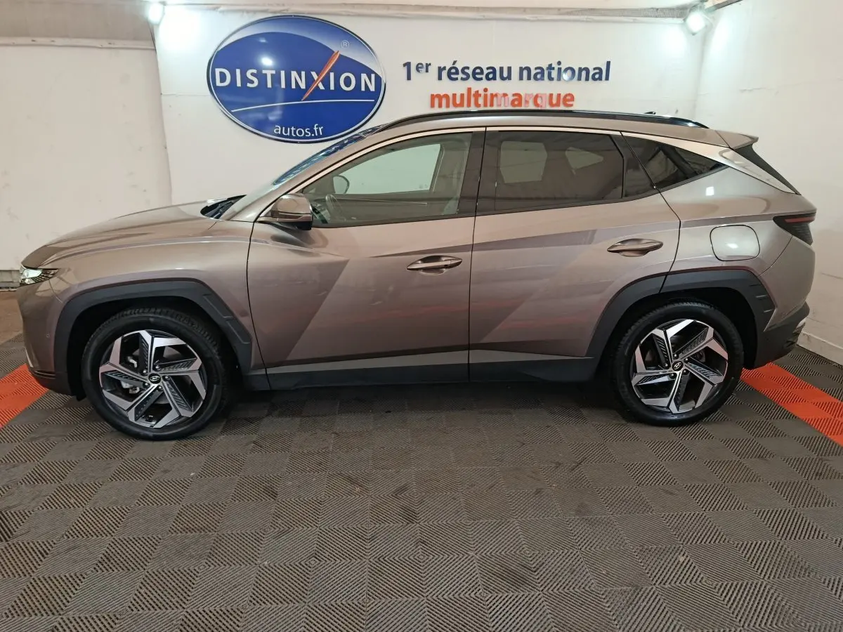 Profil côté gauche du SUV Hyundai Tucson marron 2022 avec jantes alliage et lignes anguleuses marquées.