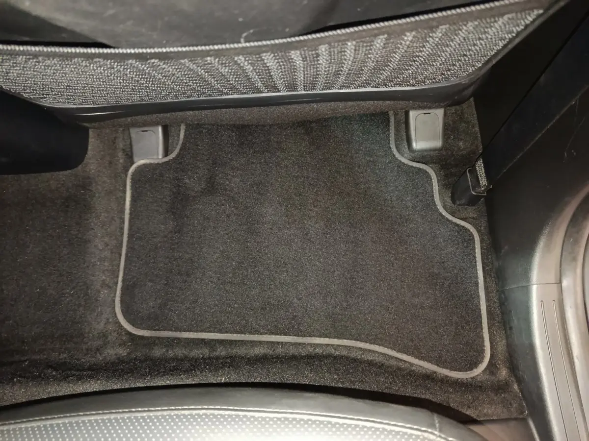 Tapis de sol noir côté passager arrière du Hyundai Tucson 1.6 PHEV marron, vue intérieure rapprochée.