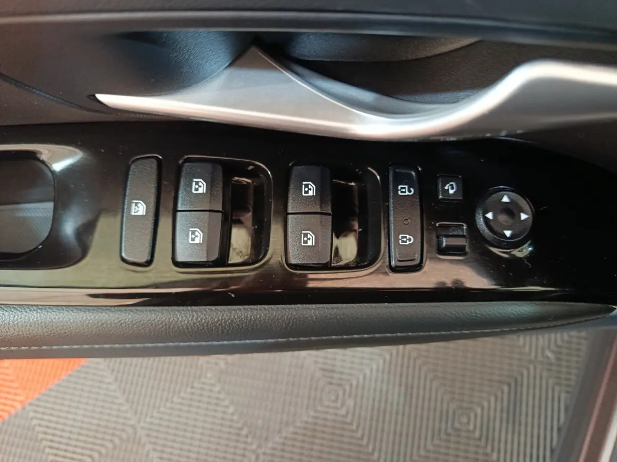 Gros plan sur la commande des vitres et rétroviseurs côté conducteur du Hyundai Tucson marron 2022.