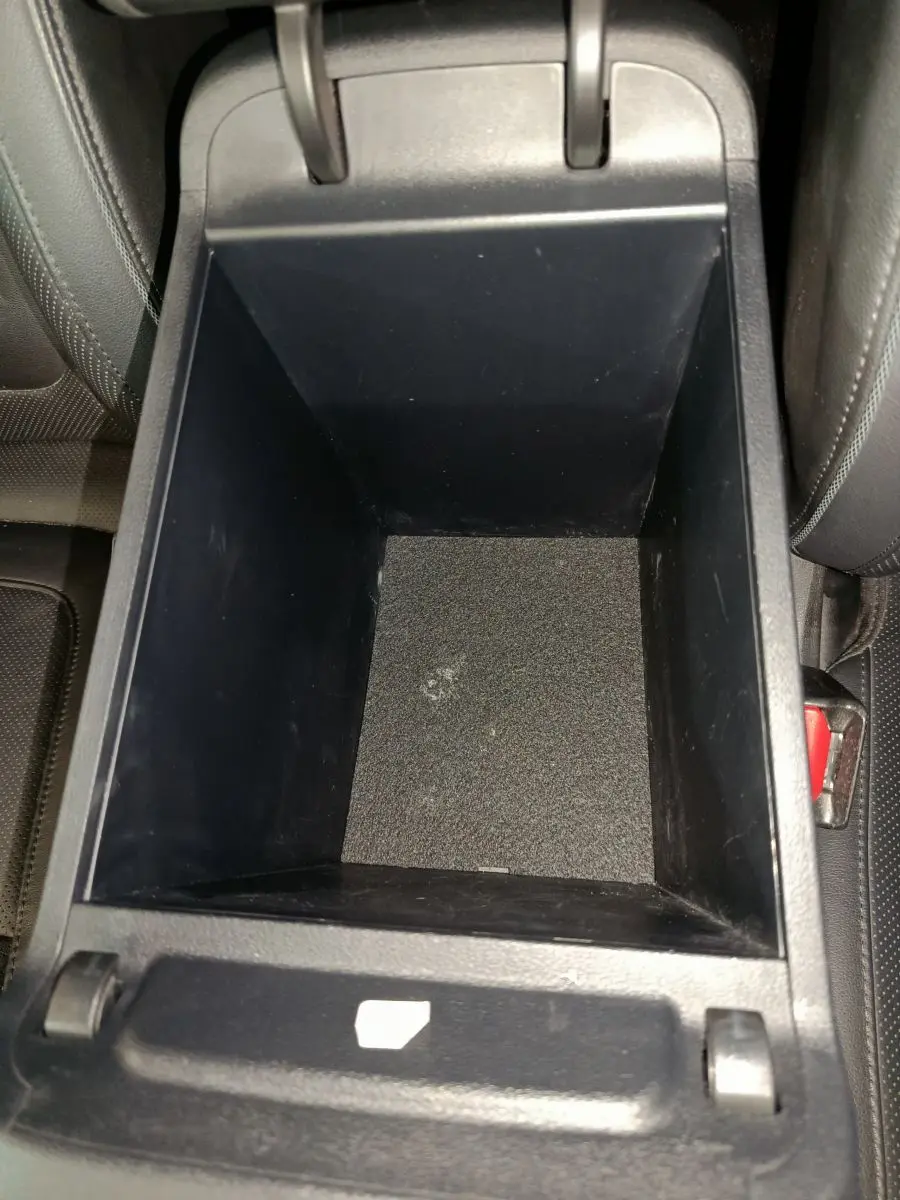 Vue rapprochée de la console centrale noire ouverte du Hyundai Tucson 2022, montrant le rangement intérieur vide.