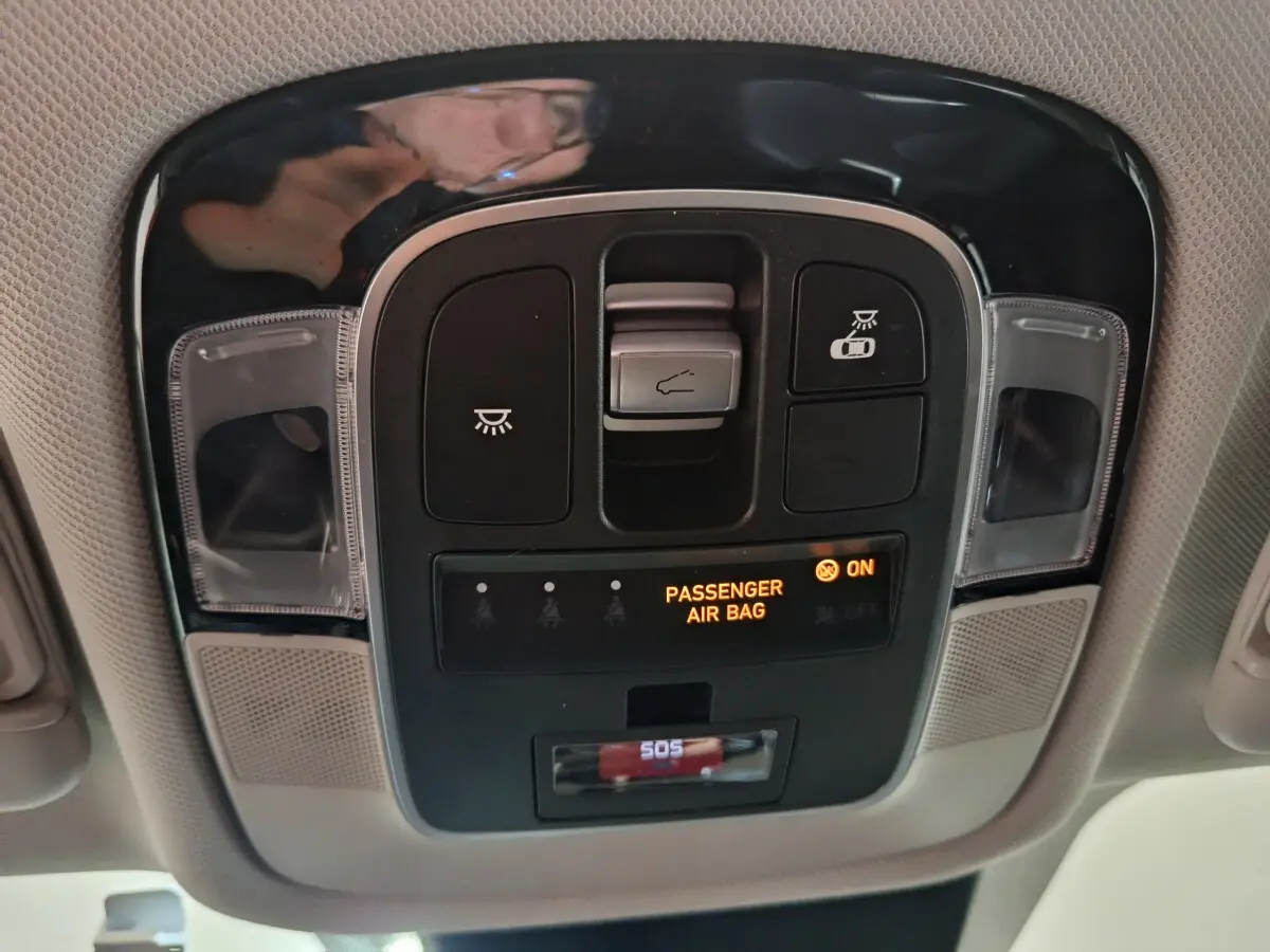 Vue en gros plan du panneau de commandes au plafond du Hyundai Tucson marron 2022, avec indicateur airbag passager allumé.
