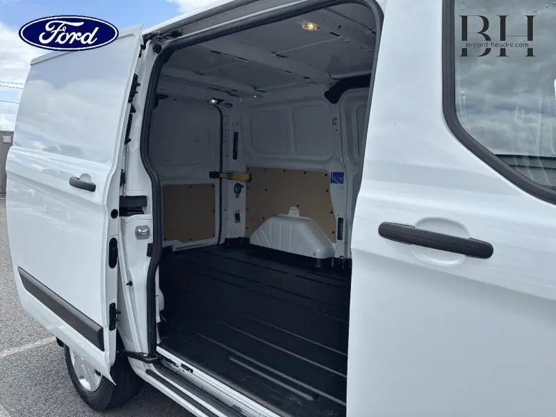 Vue latérale droite du Ford Transit Custom Fourgon blanc Glacier 2023 avec porte coulissante ouverte montrant l'intérieur vide et éclairé.
