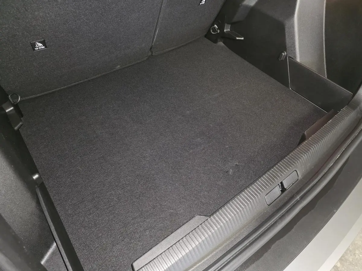Vue plongeante sur le coffre spacieux et propre du Peugeot 2008 gris métallisé, avec seuil de coffre gris météor.