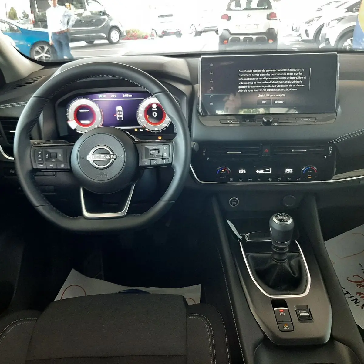 Vue intérieure du tableau de bord du Nissan Qashqai blanc lunaire 2022, avec volant multifonction et écran tactile central.