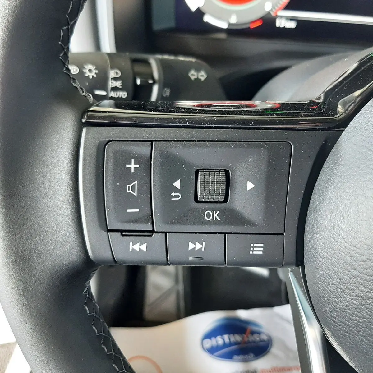 Gros plan sur les commandes noires du volant du Nissan Qashqai blanc lunaire 2022, version N-Connecta.