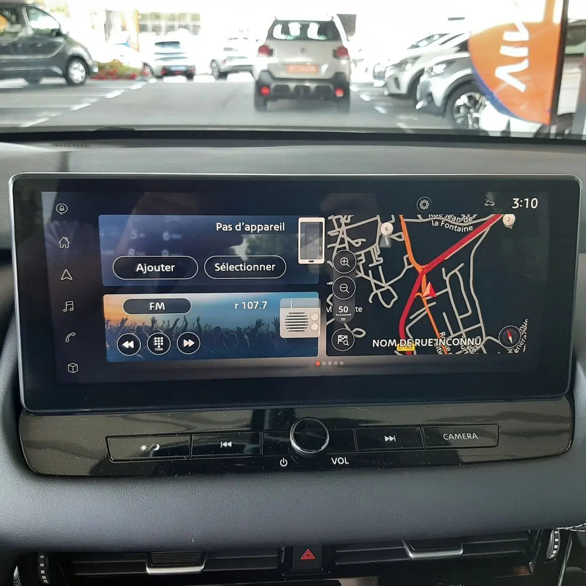 Écran tactile central du Nissan Qashqai blanc lunaire 2022 affichant navigation et radio FM, vue intérieure avant.