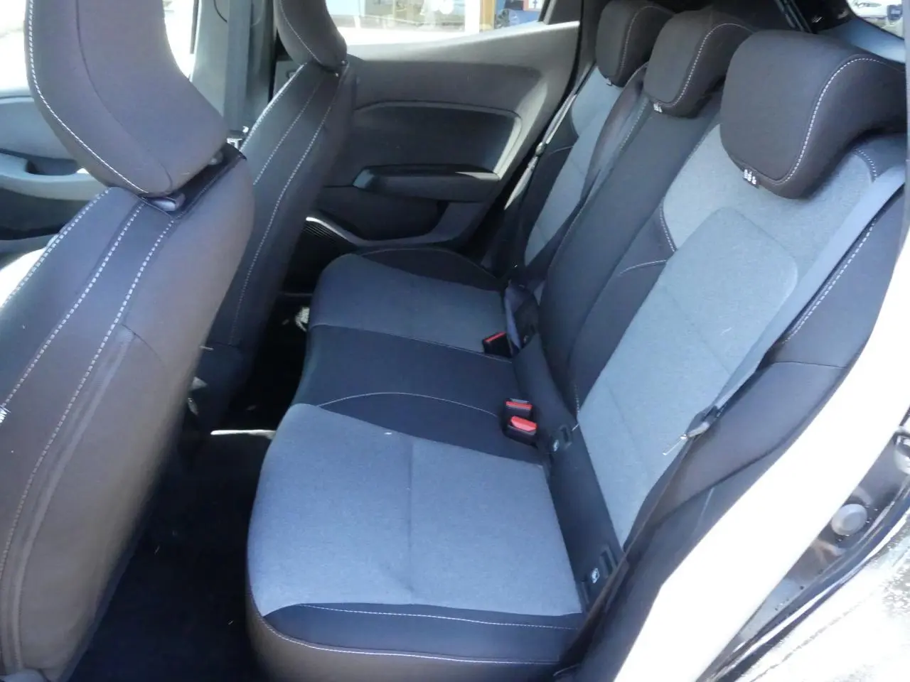 Vue intérieure côté droit des sièges arrière gris et noirs de la Renault Clio 2025 avec appuie-têtes réglables.