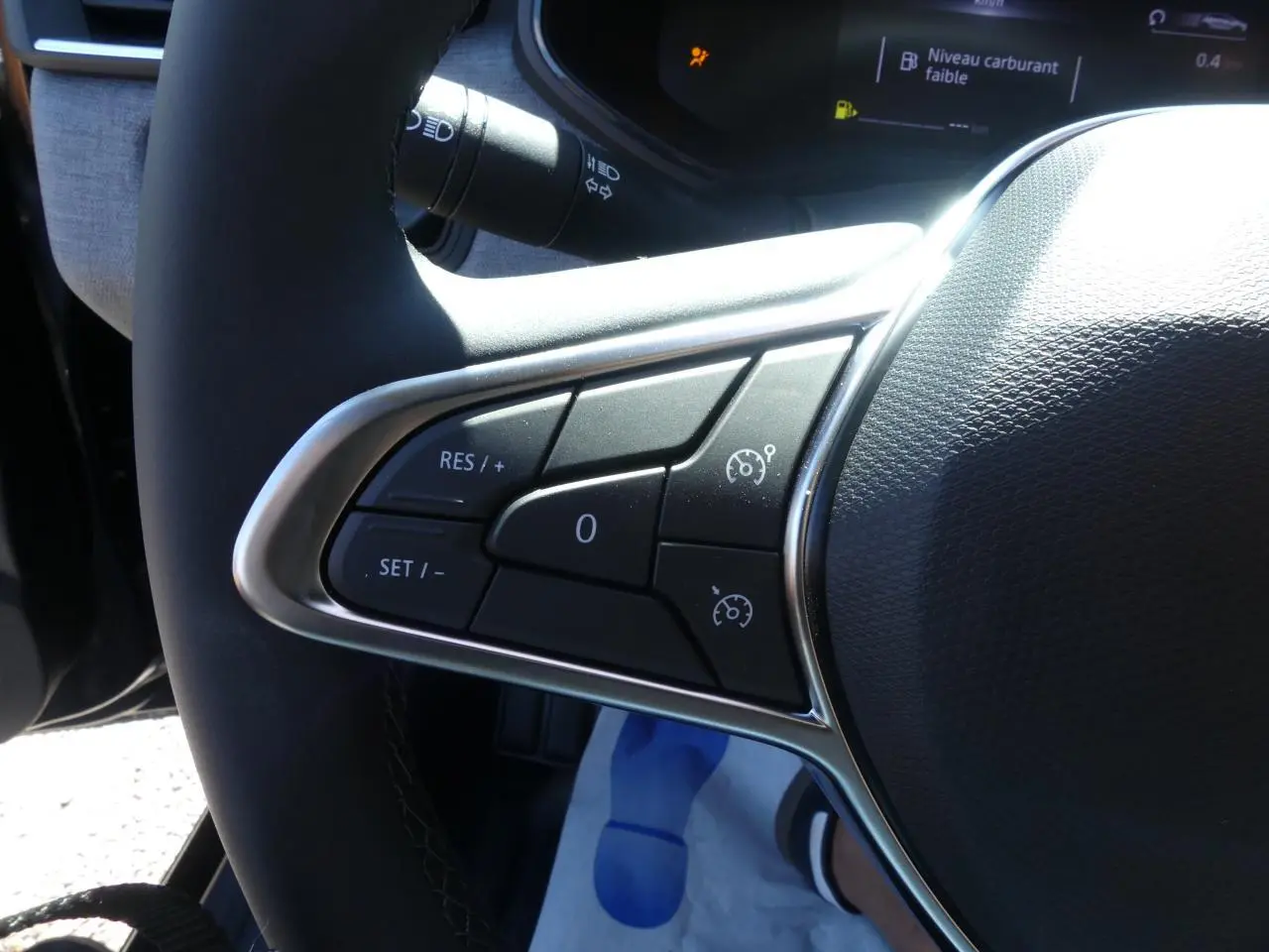 Gros plan sur les commandes de régulateur de vitesse au volant de la Renault Clio 1.5 Blue dCi noir métallisé 2025