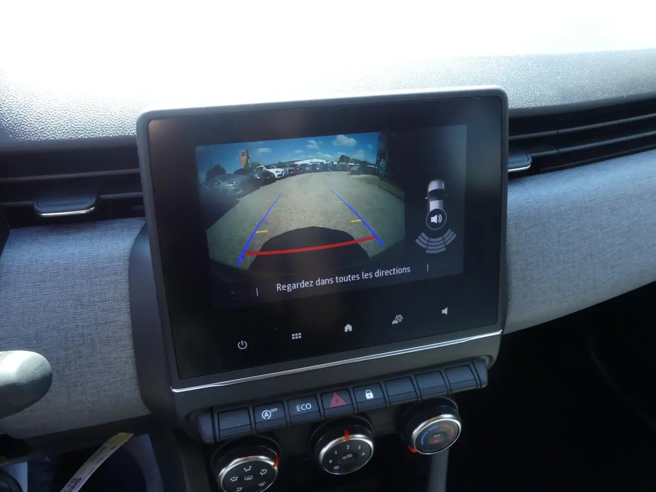 Écran tactile 7 pouces affichant la caméra de recul dans l'habitacle d'une Renault Clio noire 2025.