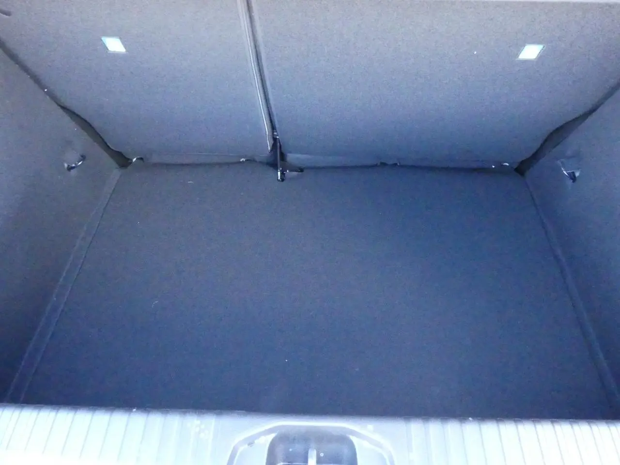 Coffre spacieux de la Renault Clio 2025, version 1.5 Blue dCi noir métallisé, avec banquette arrière rabattue.