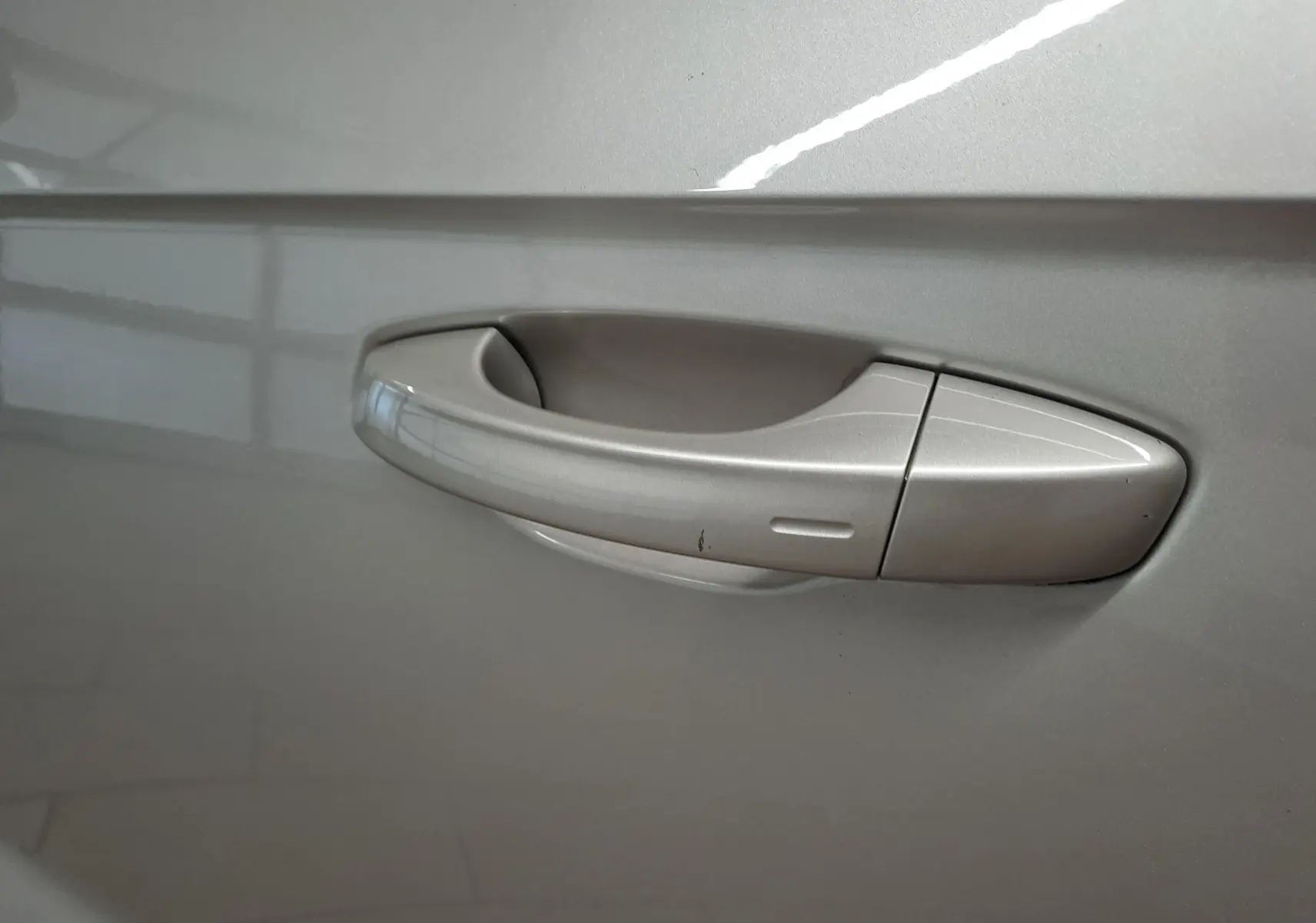 Poignée de porte côté gauche gris ivoire métallisé du Volkswagen T-Roc Cabriolet 1.5 TSI R-Line 2022 avec capote noire.