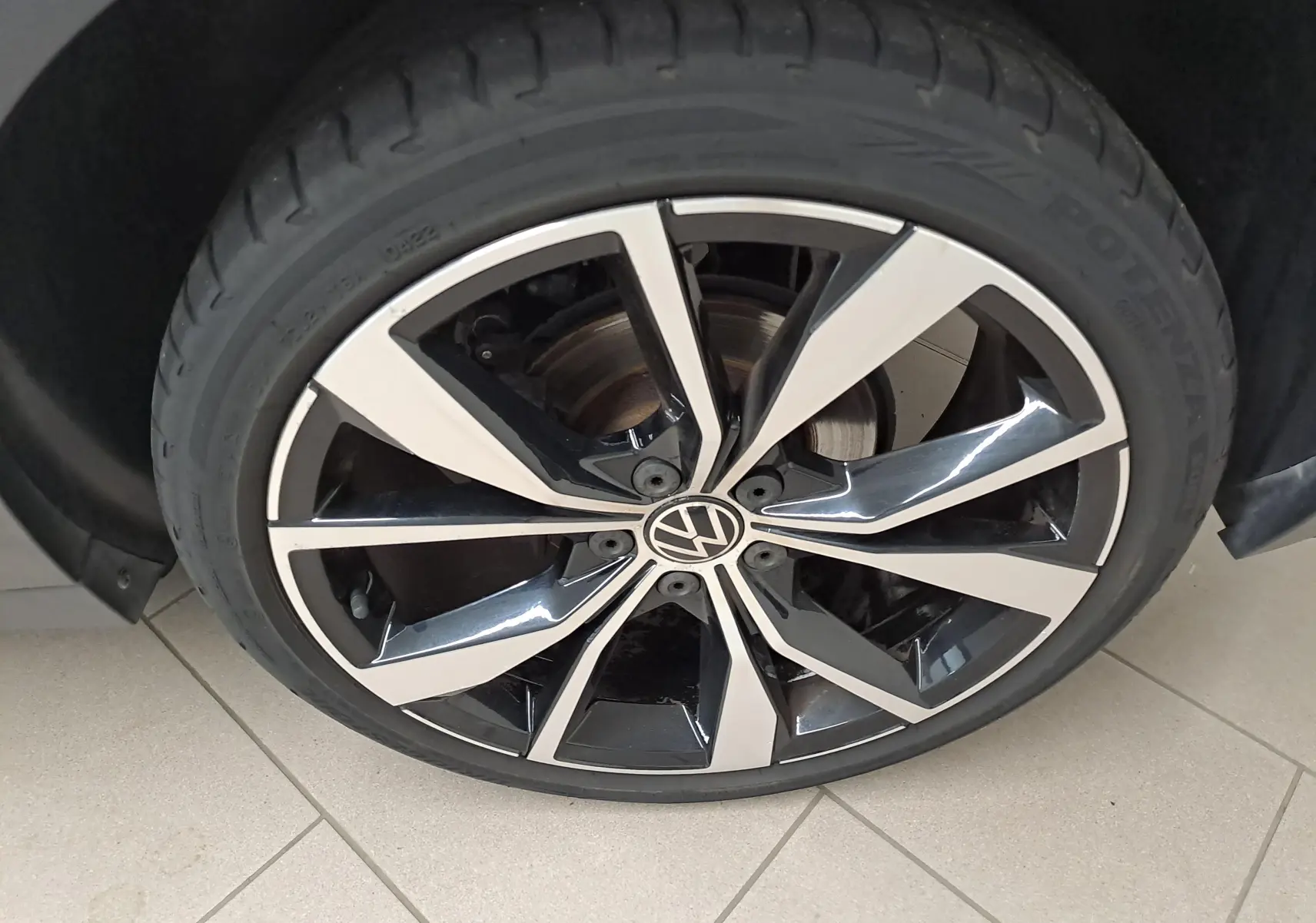 Gros plan sur la jante alliage 19'' Misano bicolore noir et argent avec logo Volkswagen au centre.