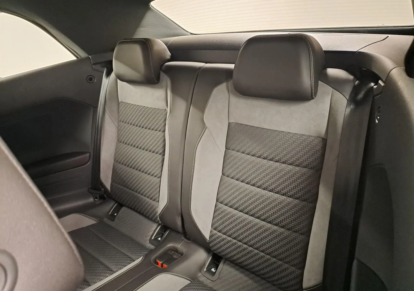 Vue intérieure des sièges arrière en tissu et cuir noir et gris du Volkswagen T-Roc Cabriolet 2022 finition R-Line.