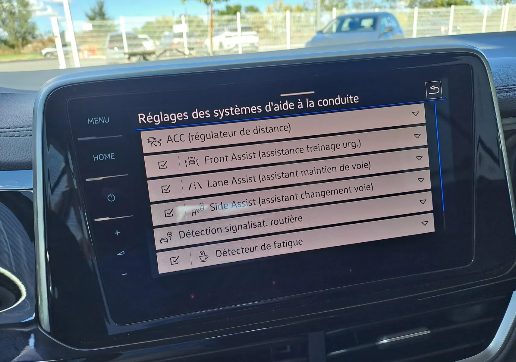 Écran tactile intérieur du Volkswagen T-Roc Cabriolet 2022 affichant les réglages des aides à la conduite.