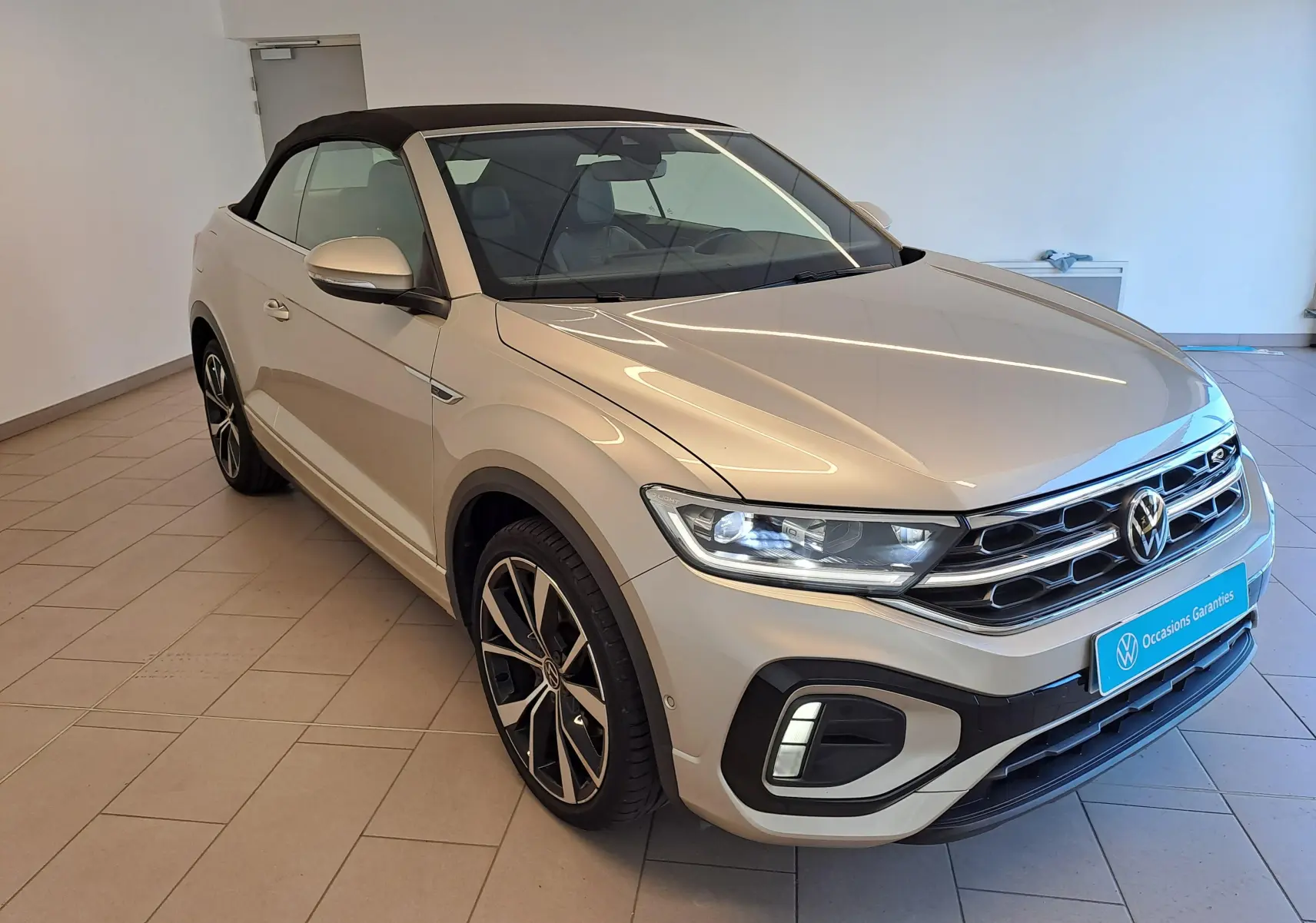 Volkswagen T-Roc Cabriolet gris ivoire vue 3/4 avant avec capote noire et jantes alliage 19 pouces Misano.
