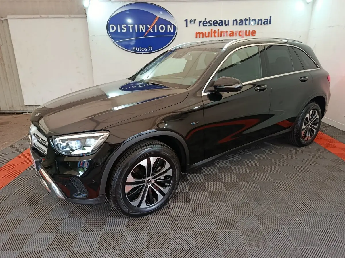 Mercedes GLC 300 e Business Line noir vu en 3/4 avant droit, avec jantes alliage et phares LED allumés.