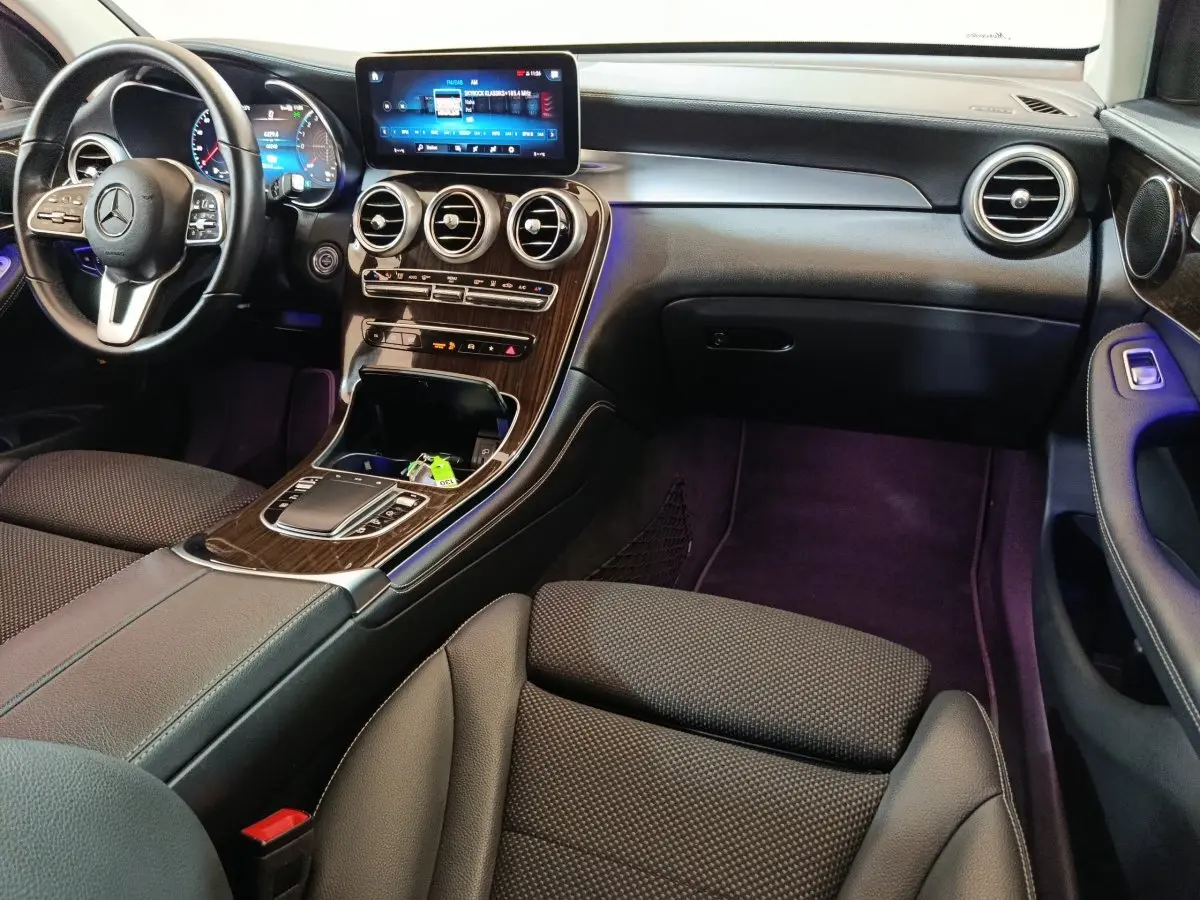 Intérieur noir du Mercedes GLC 300 e Business Line 2020, vue côté passager avec écran tactile et tableau de bord bois.