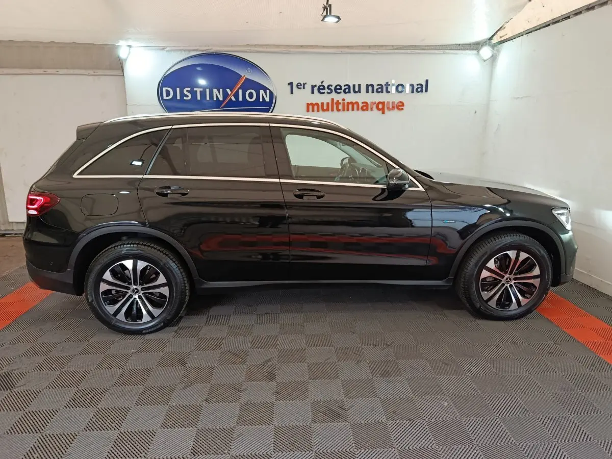 Profil côté droit d'un Mercedes GLC 300 e Business Line noir, hybride rechargeable, avec jantes alliage et vitres teintées.