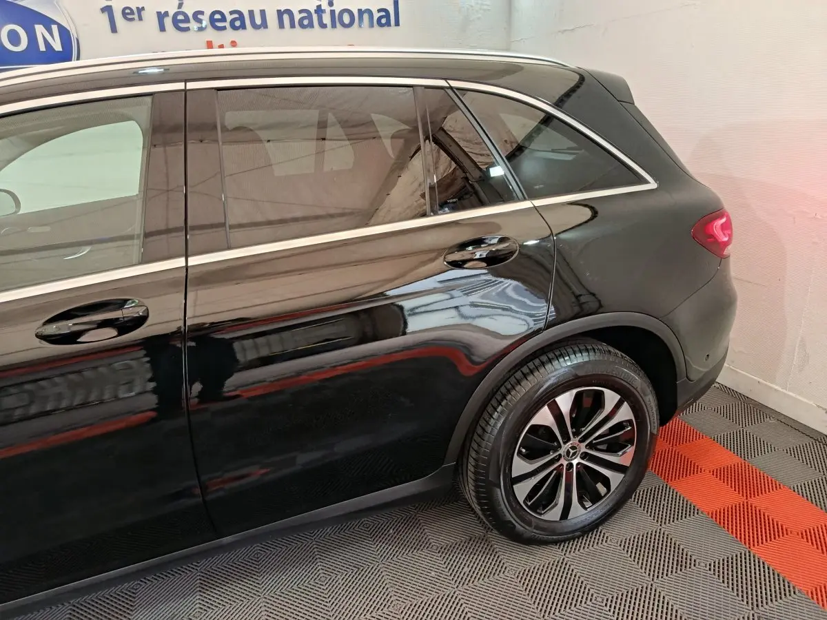 Vue latérale côté droit du Mercedes GLC 300 e Business Line noir, mettant en valeur la roue arrière et les lignes élégantes.