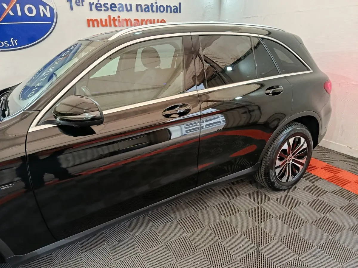 Profil côté gauche d'un Mercedes GLC 300 e Business Line noir, avec jantes alliage et rétroviseur électrique.